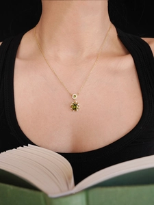 Close-up of 18K gold plated oval green zircon pendant necklace on female model