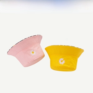 Detail of embroidered daisy on yellow and pink reversible cotton bucket hats