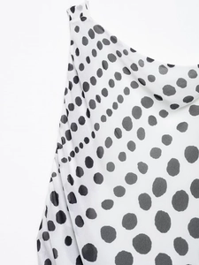 Close-up of artistic black and white polka dot print with draped neckline detail