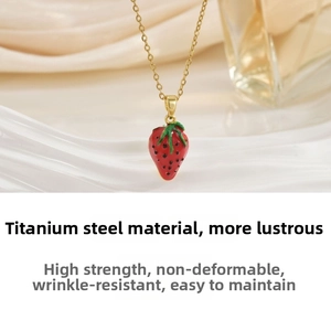 Macro shot of titanium steel necklace with a red enamel strawberry pendant detail