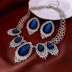 French luxury jewelry set with blue teardrop pendants and sparkling silver chain