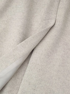 Détail du manteau en laine grise montrant la texture du tissu et la doublure intérieure