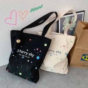 Détail de sacs cabas en toile noir et beige avec imprimé Starry Sky et larges poignées