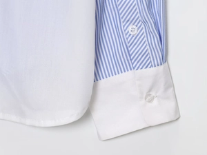 Detail eines blau gestreiften Hemdes mit weißer Manschette und transparentem Knopf