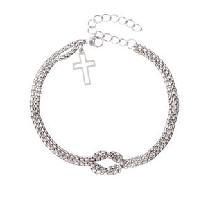 Macro shot of silver-colored double-layer chain bracelet with cross pendant and knot detail