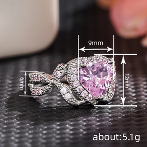 Pink heart zirconia ring with twisted band and diamond accents on black stand