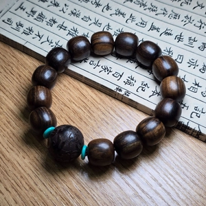 Bracelet en bois d'agar marron avec perles turquoise et bille sculptée sur bois sombre