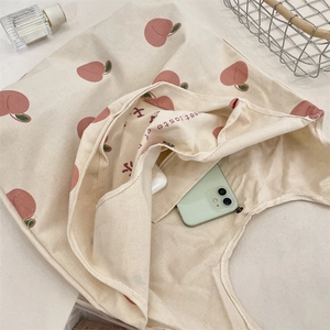 Detail of peach print canvas tote showing magnetic closure and interior pocket