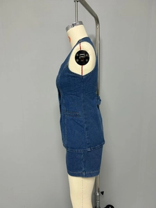 Détails de couture sur le côté d'un ensemble en jean bleu foncé avec gilet et jupe
