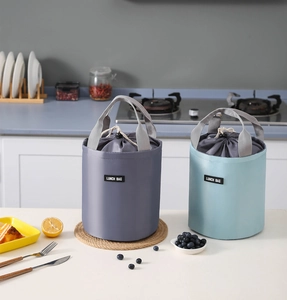 Close-up of insulated cylindrical lunch bag with drawstring closure and sturdy handle