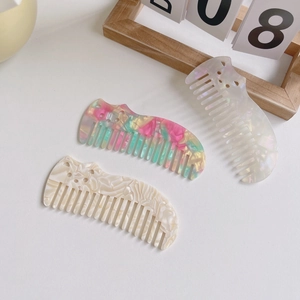 Three acetate hair combs set with tortoiseshell, pearl white and marble patterns