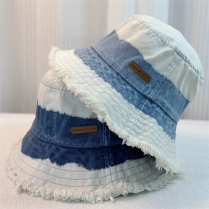Striped denim bucket hat in dark and light blue with frayed edges for sun protection