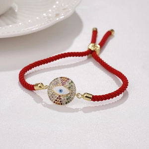 Detail eines roten Evil Eye Armbands mit bunten Kristallen und goldenem Verschluss
