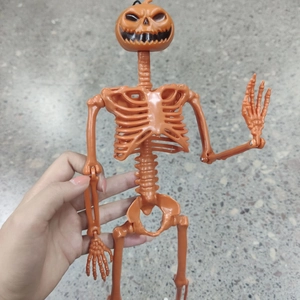 Close-up of posable Halloween skeleton toy with an orange pumpkin head and movable joints