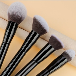 Close-up of assorted makeup brushes with soft gradient bristles and black handles