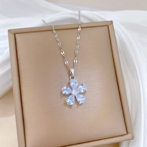Close-up of a silver flower pendant necklace with blue crystals on a jewelry box