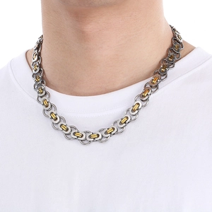 Close-up of a two-tone silver and gold chain necklace worn by a male model