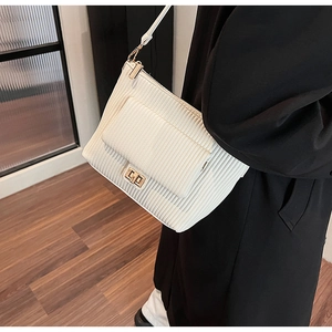 Vue détaillée de la texture plissée blanc cassé et du fermoir doré de ce sac à main