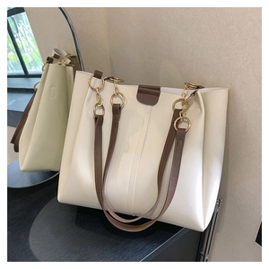 Minimalist beige tote bag with brown straps reflected in a stylish circular mirror