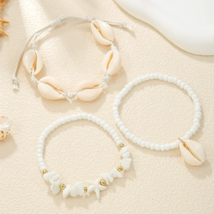 Detailed set of three shell and bead bracelets with starfish charms and white pebbles