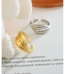 Macro shot of 18K gold and silver plated titanium steel rings on a minimalist white backdrop