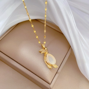 Detail of gold phoenix pendant with white oval stone on luxury jewelry display