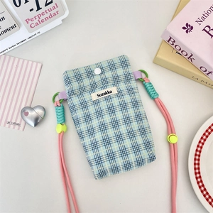 Detail of plaid crossbody phone bag with pink braided strap and Sozakka label