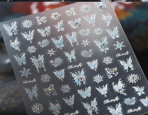 Detail of 3D embossed butterfly and snowflake nail stickers with iridescent aurora finish