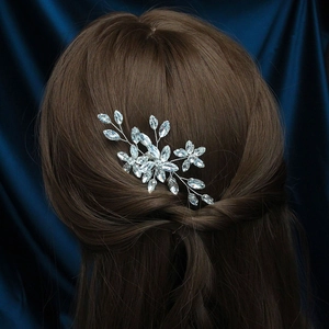 Detail view of silver metal hair comb with sparkling crystals on dark hair