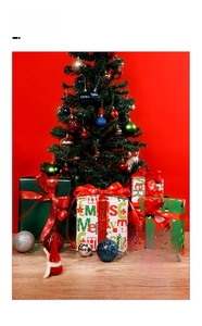 Close-up of Christmas gift wrap set with red ribbons, festive balls, and green paper