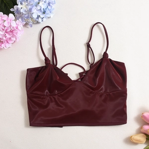 Flat lay of a wine red satin crop top with thin straps and glossy texture finish