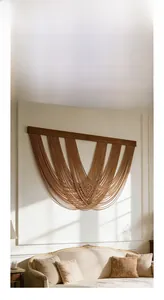 Detail of bohemian wall hanging featuring solid wood bar and natural fiber layered tassels