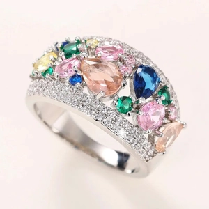 Macro shot of silver-tone wide ring featuring multi-colored pear-cut stones and pavé crystals