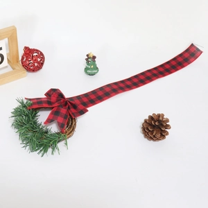 Detailed view of mini Christmas wreath with red and black buffalo plaid bow and greenery