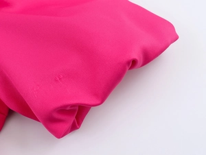 Detailansicht der rosa Kunstfaser-Textur mit eleganten Falten und glatter Oberfläche