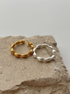 Macro view of S925 sterling silver stamp on ripple-textured gold and silver rings