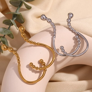 Detailed view of U-shaped gold and silver nipple rings with beaded texture design