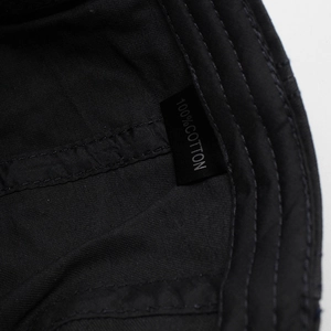 Detail shot of the 100% cotton wash label and fine twill weave of the black beret cap