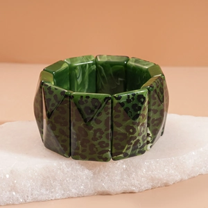 Detail of chunky acrylic bangle featuring green marble resin and leopard print patterns