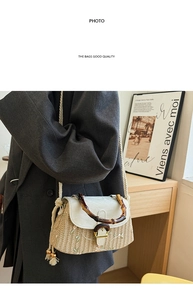 Detail of straw woven bag with floral embroidery and brown bamboo handle with wooden knob