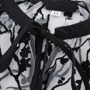 Sheer mesh long sleeve top with floral flocking patterns and tie-up lace collar