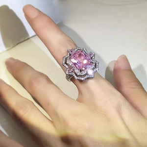 Detail of a pink square-cut high carbon diamond ring with side stone halo on model