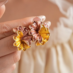 Macro shot of vintage gold and pink enamel flower earrings with sparkling small diamonds
