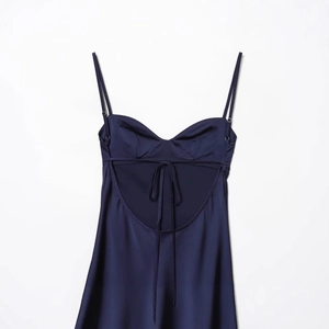 Satin dark blue slip dress with backless lace-up design on white background