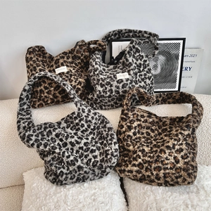Detail of leopard print faux fur tote bags in brown and grey plush textures