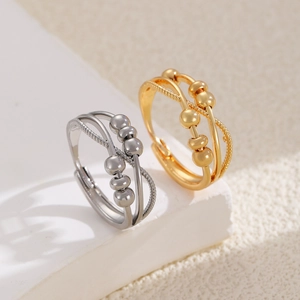 Rotating fidget rings with infinity loops and movable beads in gold and silver finish
