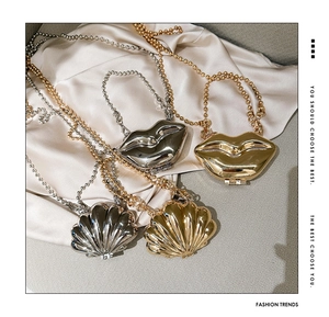 Detailed display of mini metal lip and shell shaped bags in gold and silver finishes