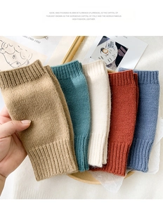 Detail of ribbed knit fingerless gloves in camel, blue, and cream wool blend fabric