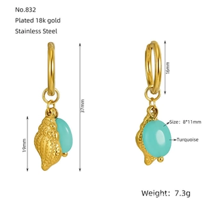 Détail de boucles d'oreilles créoles plaquées or 18k avec coquillages et turquoise