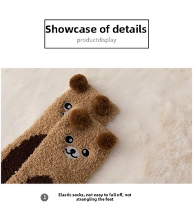 Detailed close-up of thick coral fleece socks with 3D bear ears and elastic cuffs